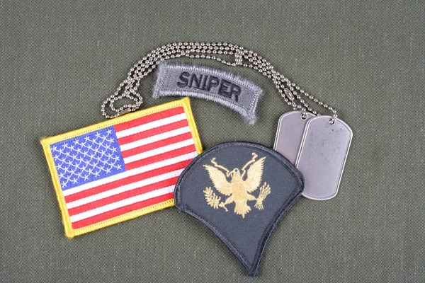 KIEV, UKRAINE - August 21, 2015.  US ARMY Specialist rank patch, sniper tab, flag patch and dog tag on olive green uniform — Stock Photo, Image