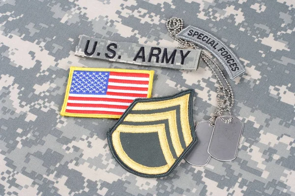 KIEV, UKRAINE - August 21, 2015. US ARMY Staff Sergeant rank patch, special forces tab, flag patch,  with dog tag on camouflage uniform — Stock Photo, Image