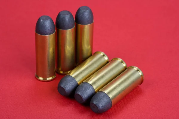 Los cartuchos Revolver .45 Período Wild West sobre fondo rojo — Foto de Stock