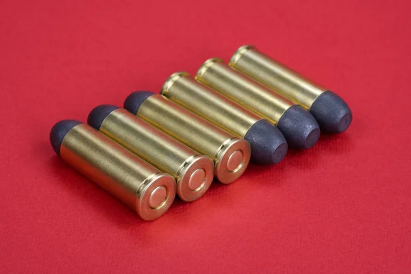 Los cartuchos Revolver .45 Período Wild West sobre fondo rojo — Foto de Stock