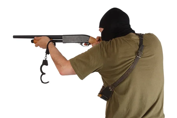Jail break - robber in black mask with shotgun removing handcuffs — Stock Photo, Image