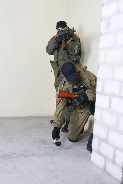 Mercenary with AK-47 rifle throw a grenade — Stock Photo, Image