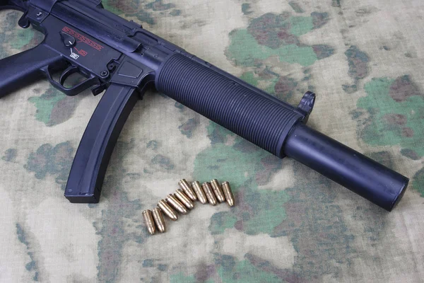 Submetralhadora MP5 com silenciador em fundo camuflado — Fotografia de Stock