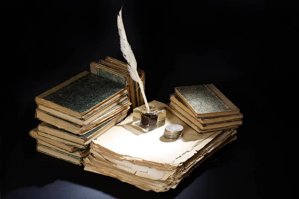 Old fountain pen, papers and inkwell and silver coins on a black background — Stock Photo, Image