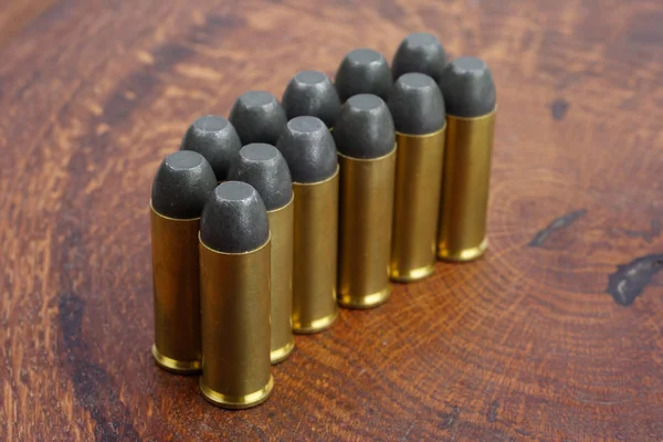 Revolver cartridges .45 Cal Wild West period on wooden background