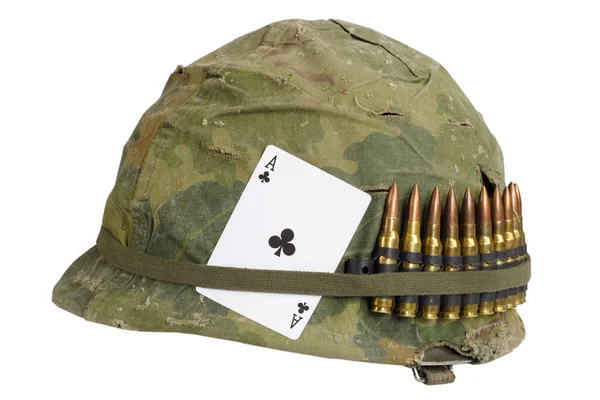 美国陆军头盔越南战争时期用伪装盖和弹药带和护身符 王牌俱乐部玩牌 — 图库照片