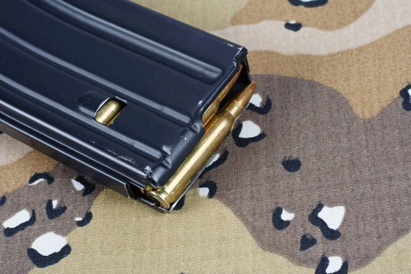 US ARMY M-16 rifle magazine with cartridges on camouflage uniform background