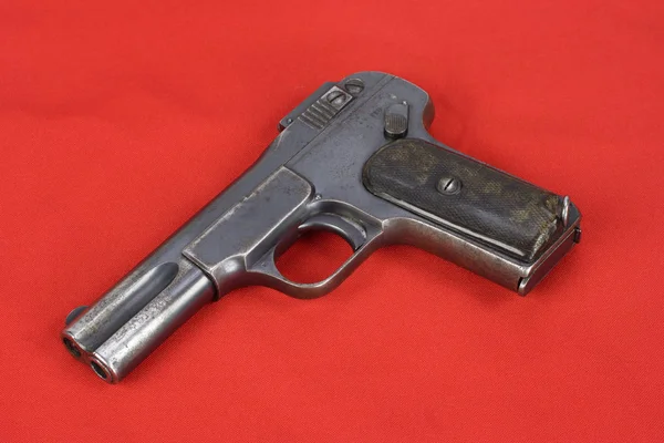 Vecchia pistola arrugginita su sfondo rosso — Foto Stock