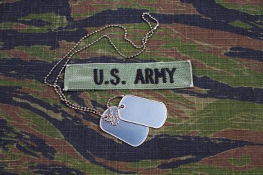 KIEV, UKRAINE - Sept 12, 2016. US ARMY branch tape and dog tags on tiger stripe camouflage uniform clipart