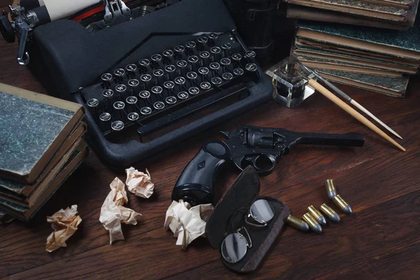 Scrivere un libro poliziesco - vecchia macchina da scrivere vintage retrò e pistola revolver con munizioni, libri, carte, penna inchiostro vecchio — Foto Stock