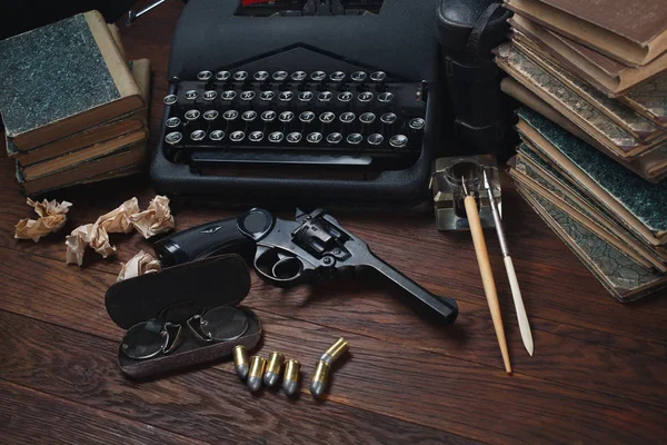 Γράφοντας ένα βιβλίο εγκληματικής φαντασίας - παλιά ρετρό γραφομηχανή εποχής και περίστροφο όπλο με πυρομαχικά, βιβλία, χαρτιά, παλιό στυλό μελάνι — Φωτογραφία Αρχείου