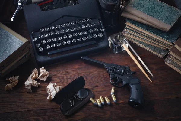 Escribir un libro de ficción del crimen - vieja máquina de escribir retro vintage y pistola de revólver con municiones, libros, papeles, pluma de tinta vieja —  Fotos de Stock