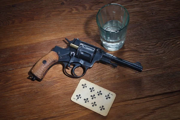Ruleta rusa - Nueve de Clubes trenzado tarjeta, vaso de vodka y revólver con un cartucho en tambor — Foto de Stock