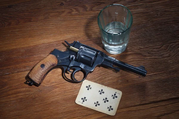 Ruleta rusa - Seven of Clubs trenzado tarjeta, vaso de vodka y revólver con un cartucho en tambor — Foto de Stock
