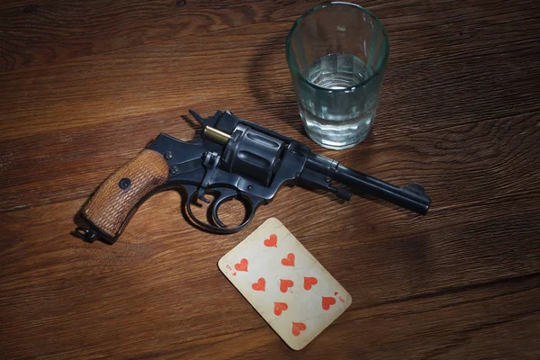 Roulette russe - Neuf des coeurs plaçant carte, verre de vodka et revolver avec une cartouche dans le tambour — Photo