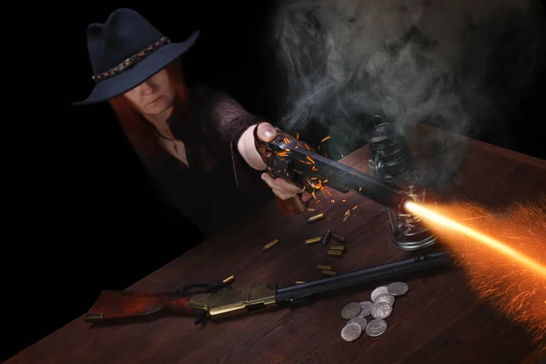 Wild west girl shooting from revolver gun at the table with ammu — Stock Photo, Image