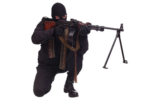 Mercenary in black uniform with machine gun and ammunition belt — Stock Photo, Image