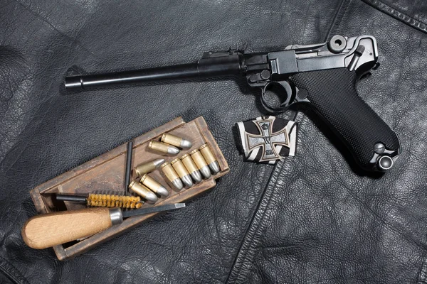 Pistola dell'esercito tedesco Parabellum "Artillery Luger" con munizioni e accessori su giacca in pelle nera — Foto Stock