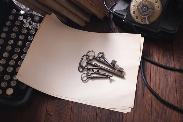 Old retro vintage typewriter and a blank sheet of paper with key on wooden board — 스톡 사진