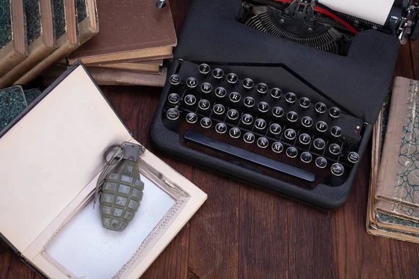 Handgranaat verborgen in een boek met oude retro typemachine — Stockfoto