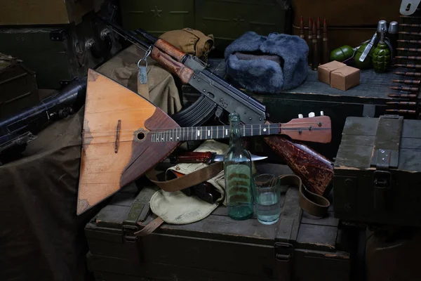 Калашников АК 47 с боеприпасами и водкой на армейском фоне . — стоковое фото