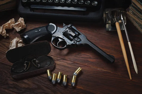Crime fiction story - old retro vintage typewriter and revolver gun with ammunitions, books, blank paper, old ink pen — 스톡 사진