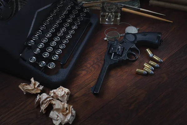 犯罪小説-古いレトロなヴィンテージタイプライターと弾薬、本、白紙、古いインクペンで回転銃 — ストック写真
