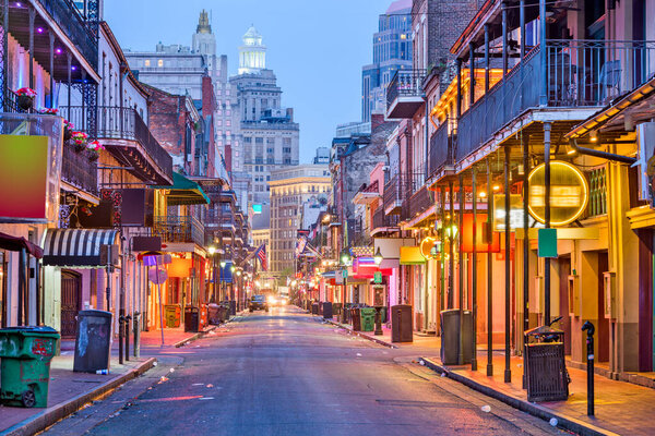 Bourbon St, New Orleans, Louisiana, USA cityscape of bars and restaurants at twilight.
