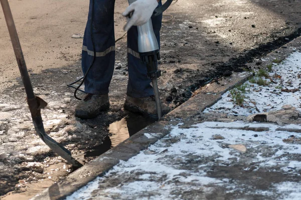 Man working a jackhammer on a city street — Stock Photo, Image