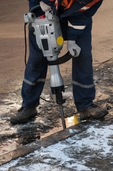 Man som arbetar en jackhammer på en stadsgata — Stockfoto
