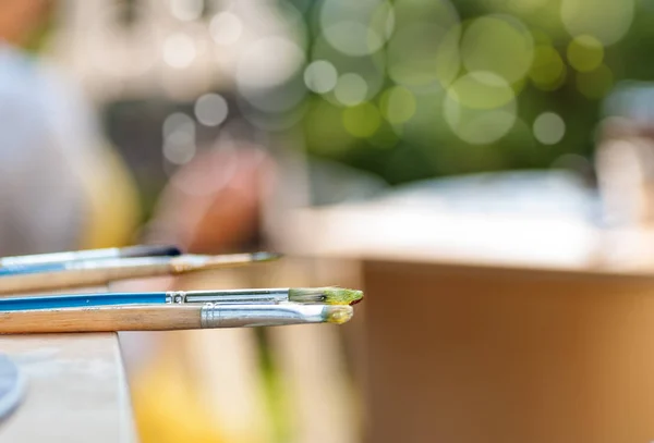 Penselen in verf op de tafel liggen — Stockfoto