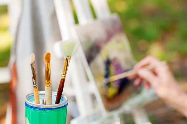 Bir cam arka plan sanatçısı çizmek için fırça bir p boyalar — Stok fotoğraf