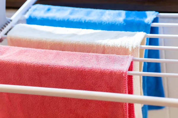 Tres toallas de colores en el primer plano secador — Foto de Stock