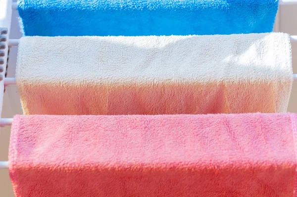 Three colored towels on the dryer close-up — Stock Photo, Image