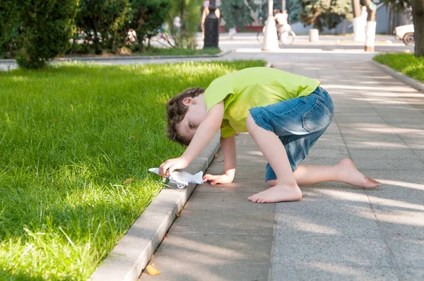 Boys playing with a plane outdoors in the park — Stock Photo, Image