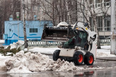 Kış aylarında şehrin sokaklarında kar temizleme makinesi