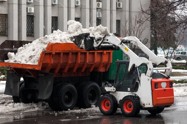 Loading snow into a truck on a city street in winter — Stock Photo, Image