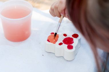 Çocuk boyalar üzerinde bir rakam alçı çizer