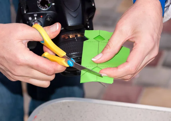 Frau schneidet bei Meisterkurs Schere aus grünem Papier — Stockfoto