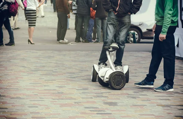 Un joven en la plaza equilibra en scooter eléctrico, ecológico — Foto de Stock