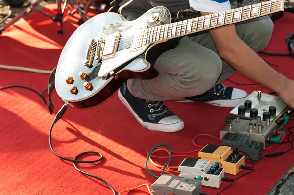 Guitarrista sintoniza el sonido antes de actuar en la calle —  Fotos de Stock