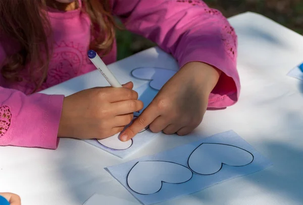 Bambino depicture su cuore di carta in una classe di padrone — Foto Stock