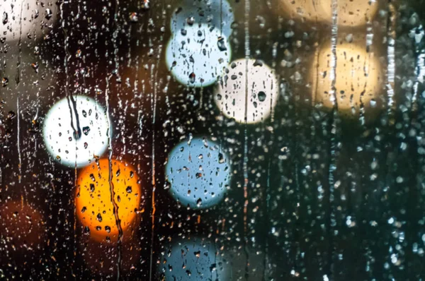 Σταγόνες βροχής στο γυαλί στο νύχτα, χρωματιστά bokeh, ηλεκτρικό κυκλοφορίας — Φωτογραφία Αρχείου