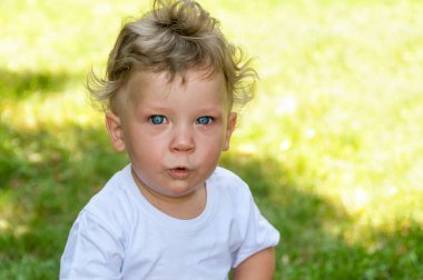 s sokakta beyaz bir t-shirt küçük kıvırcık çocuk ağlıyor