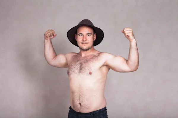 Półnagi mężczyzna w kapeluszu pozowanie i pokazując jego silne ciało — Zdjęcie stockowe