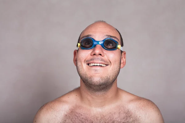 Funny man in swimming goggles daydreaming and looking up — Stockfoto