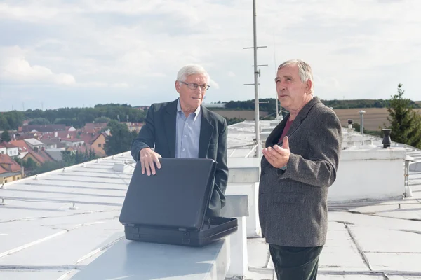 Senior businessmen discussing business deal on the roof of a bui — Stock fotografie