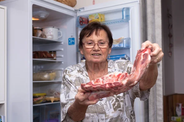 生の豚カルビを保持している年配の女性 — ストック写真