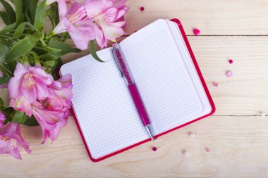 Defter ile ahşap arka plan üzerinde çiçekler