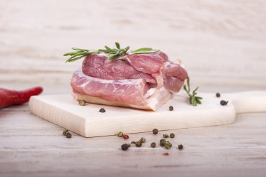 Taze et: kırmızı biber biber, dereotu ve biberiye ahşap tahta üzerinde çiğ domuz eti